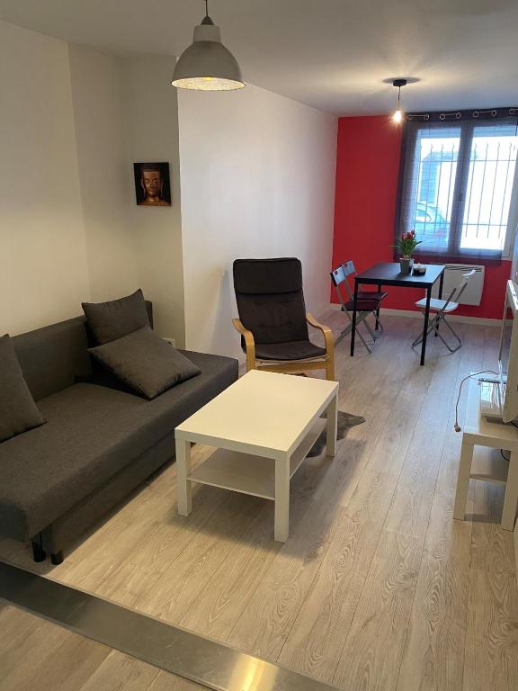 a living room with a couch and a table at The Provençal orchid in Malemort-du-Comtat