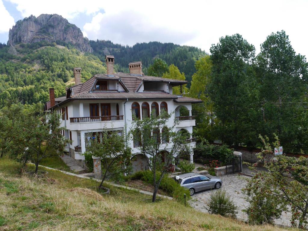 a house with a car parked in front of it at Family Hotel Silver in Smolyan
