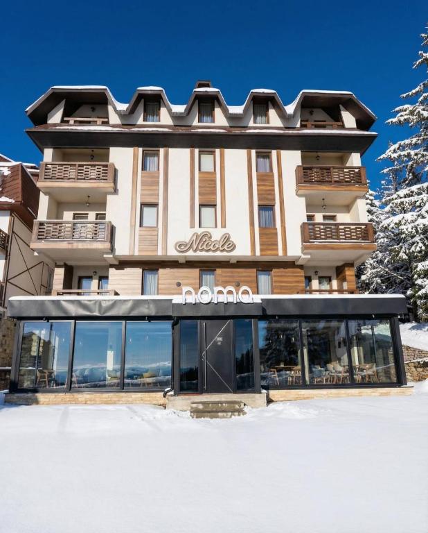 ein Hotel im Schnee mit einem Gebäude in der Unterkunft Nomakop5 in Kopaonik