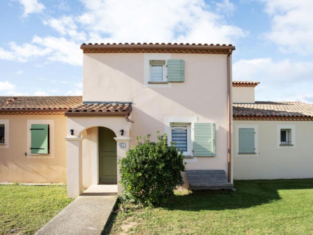 una grande casa bianca con persiane verdi di P Minervois G N02 Villa 3P4 a Homps