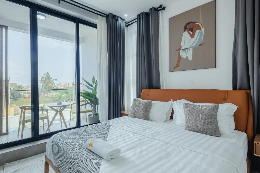 ein Schlafzimmer mit einem Bett und einem großen Fenster in der Unterkunft The Avery at Lapwing Place in Accra