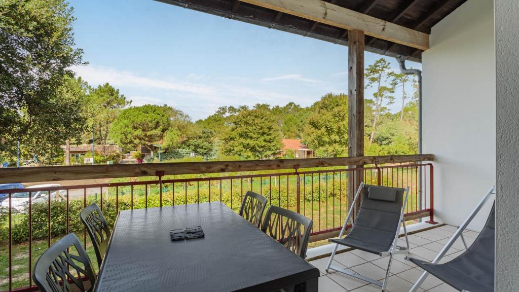 a patio with a table and chairs on a balcony at Allee des Dunes E N57 3P6 in Ondres
