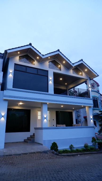 a large white house with lights on it at Villa Dalia Puncak Na5-06 in Cikundul