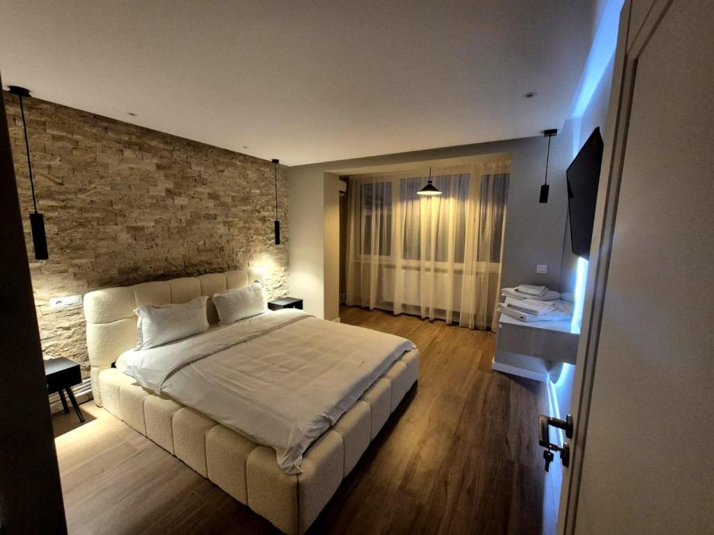 una camera da letto con un letto grande e un muro di mattoni di Alpasio Rentals 3 a Galaţi