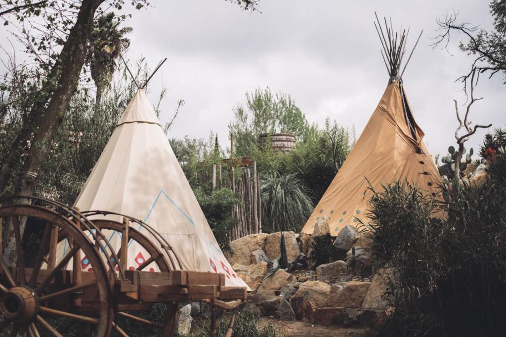 two tents sitting next to a wooden cart at Logement insolite glamping tipi et lodge Var Grimaud in Grimaud