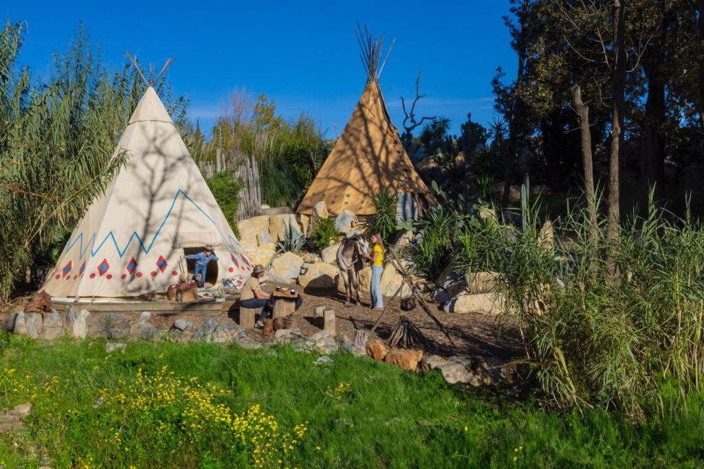 un gruppo di persone che si trovano di fronte alle tende di Tipi Indien insolite au Far west a Grimaud