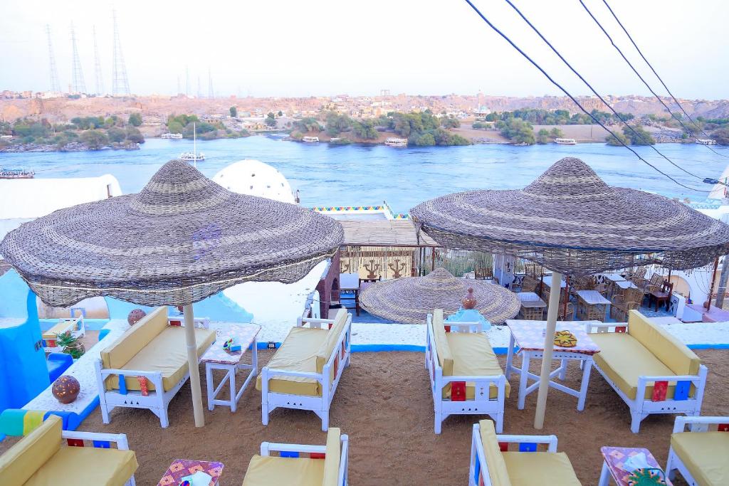 een groep stoelen en parasols op een strand bij Nubian Palace Eco Lodge - A Nubian Home Since 1959 in Aswan