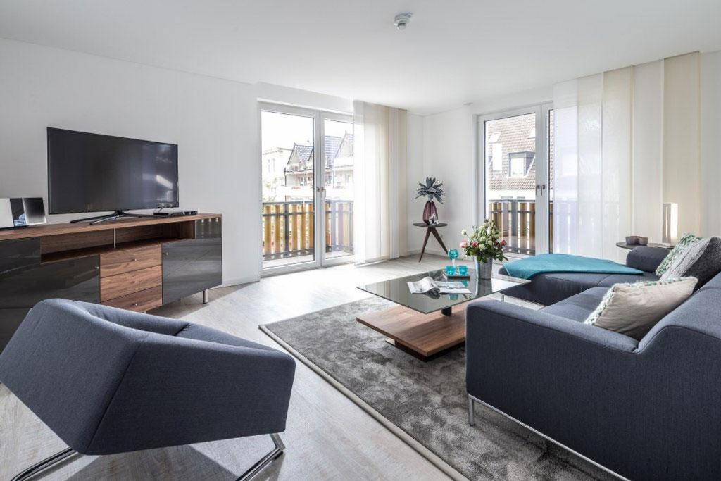 a living room with two couches and a flat screen tv at Wohnart - Fewo 8 Wohnambiente in Norderney