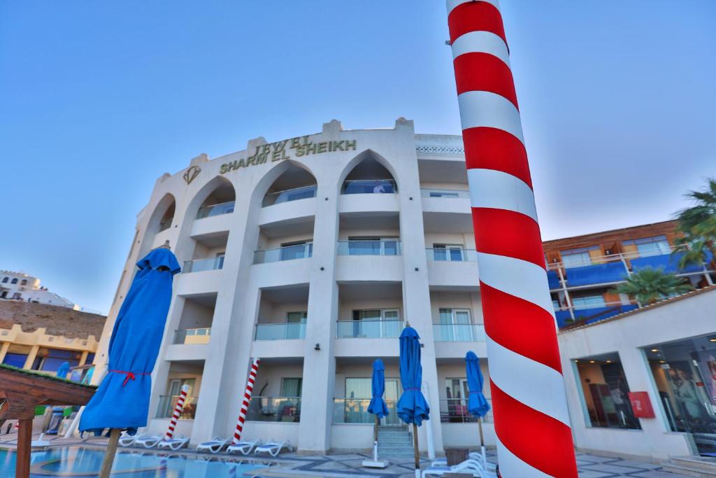 ein Hotel mit einem rot-weißen Pfosten davor in der Unterkunft Jewel Sharm El Sheikh Hotel in Sharm El Sheikh