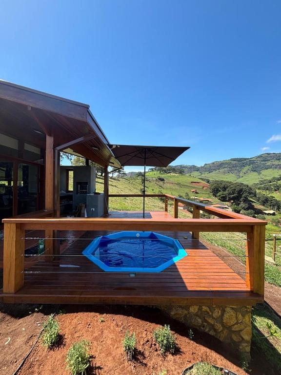 a wooden deck with an umbrella on top of it at Aura dos Ipês in Paraisópolis