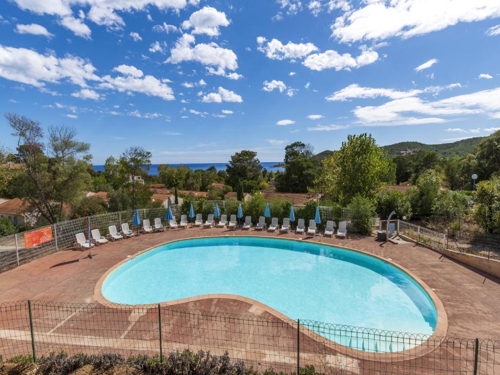 a swimming pool with chairs and umbrellas at Lisa Maria E N60 3P7 in Sari Solenzara