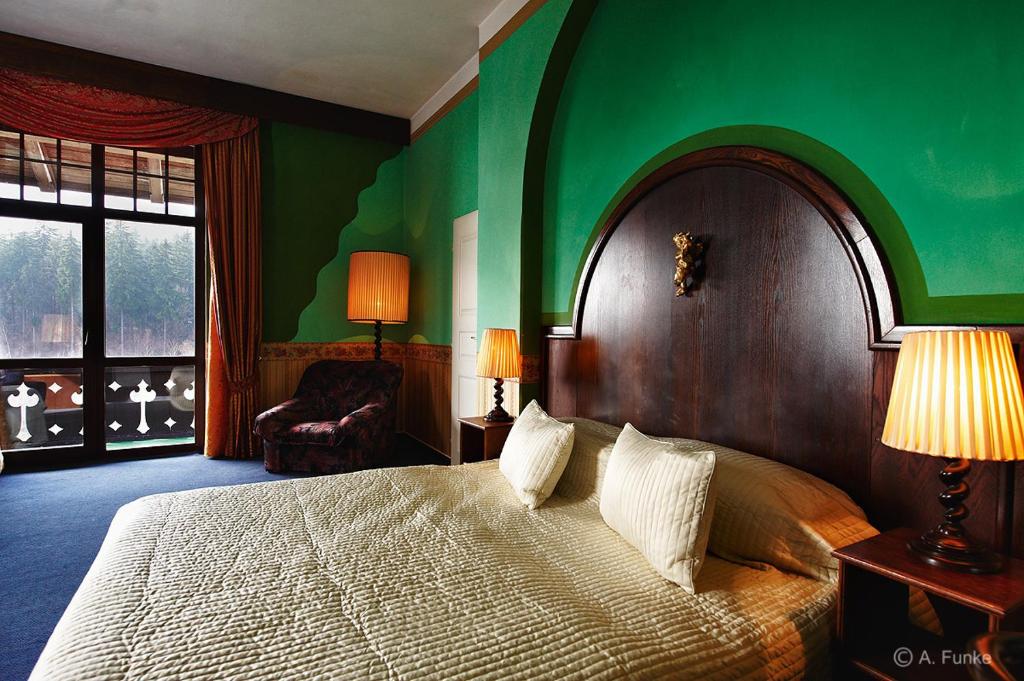 a bedroom with a large bed with a green wall at Hotel Orionka in Liberec