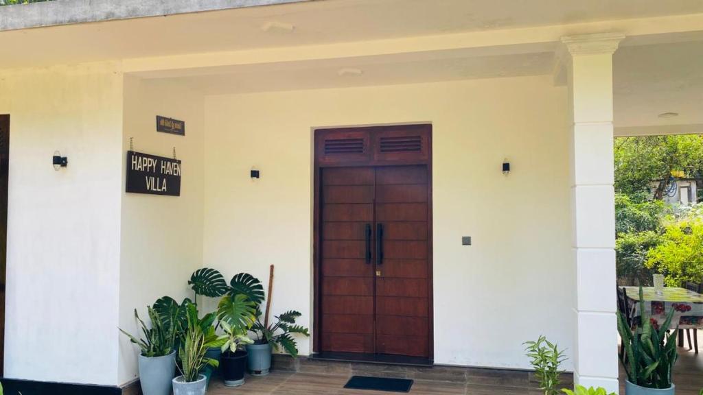 a front door of a house with potted plants at Happy Haven in Hikkaduwa