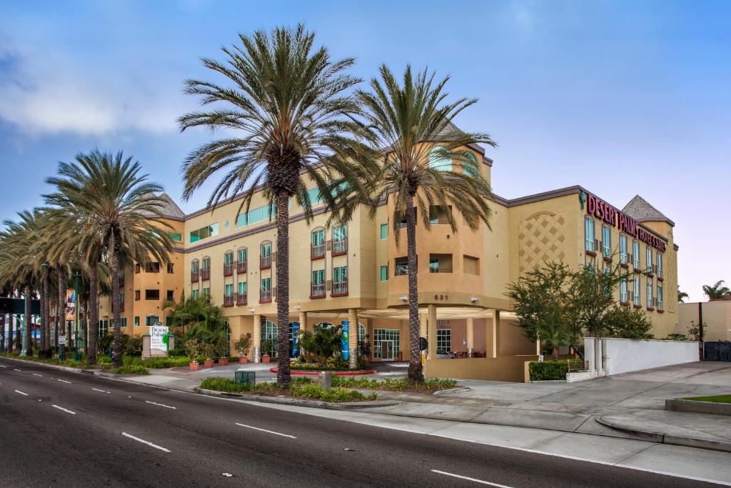 a building with palm trees in front of a street at Desert Palms Hotel & Suites Anaheim Resort in Anaheim