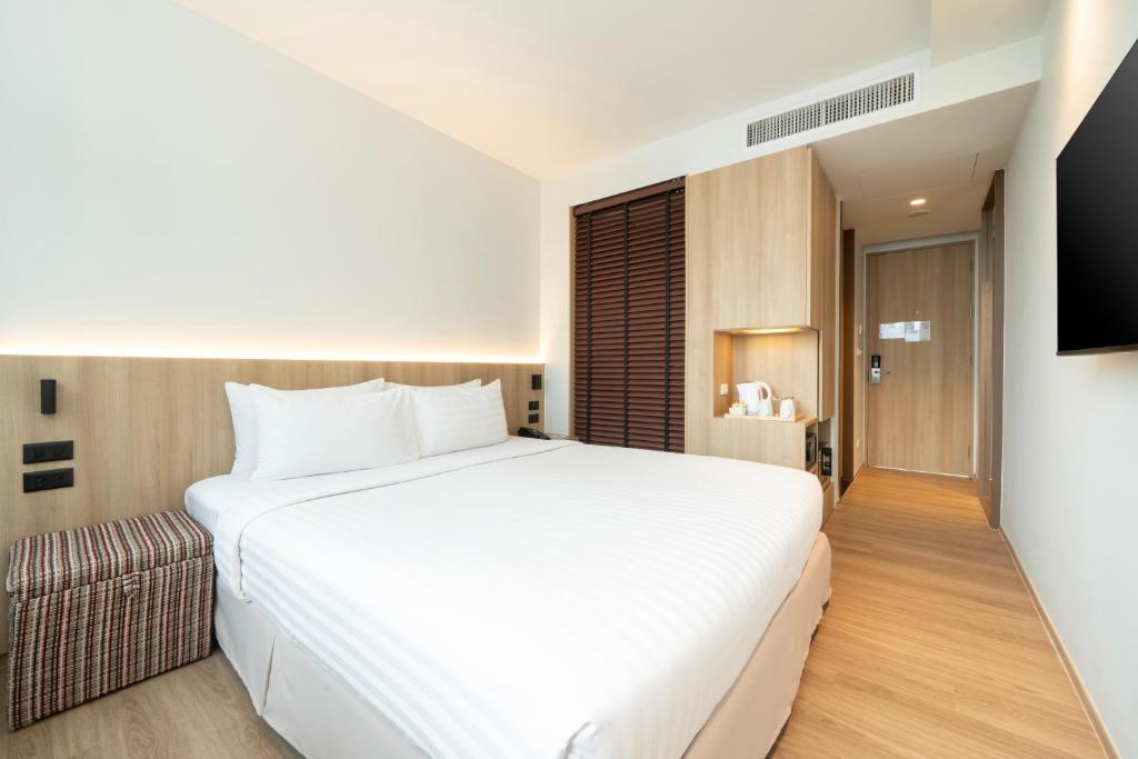 A streamlined room centered on a large double bed with a built-in refreshment station.