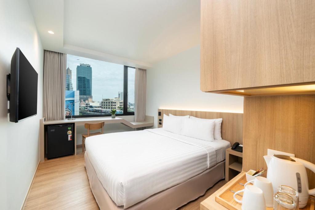 A bright double room with a city-facing window and compact work area.