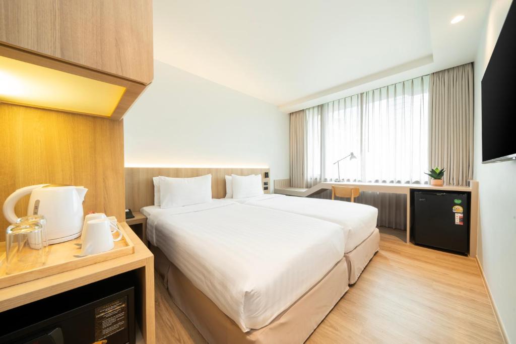 A bright twin room with a window-side desk and in-room refreshment facilities.