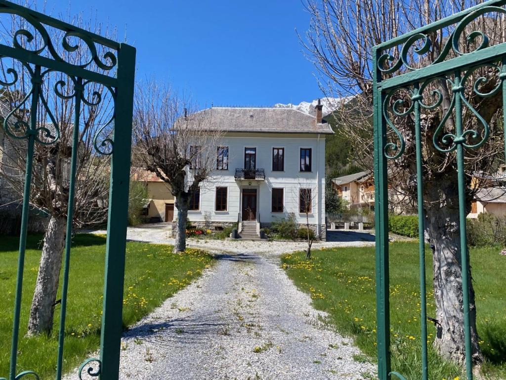 een poort voor een wit huis bij La Villa Madeleine in Jausiers