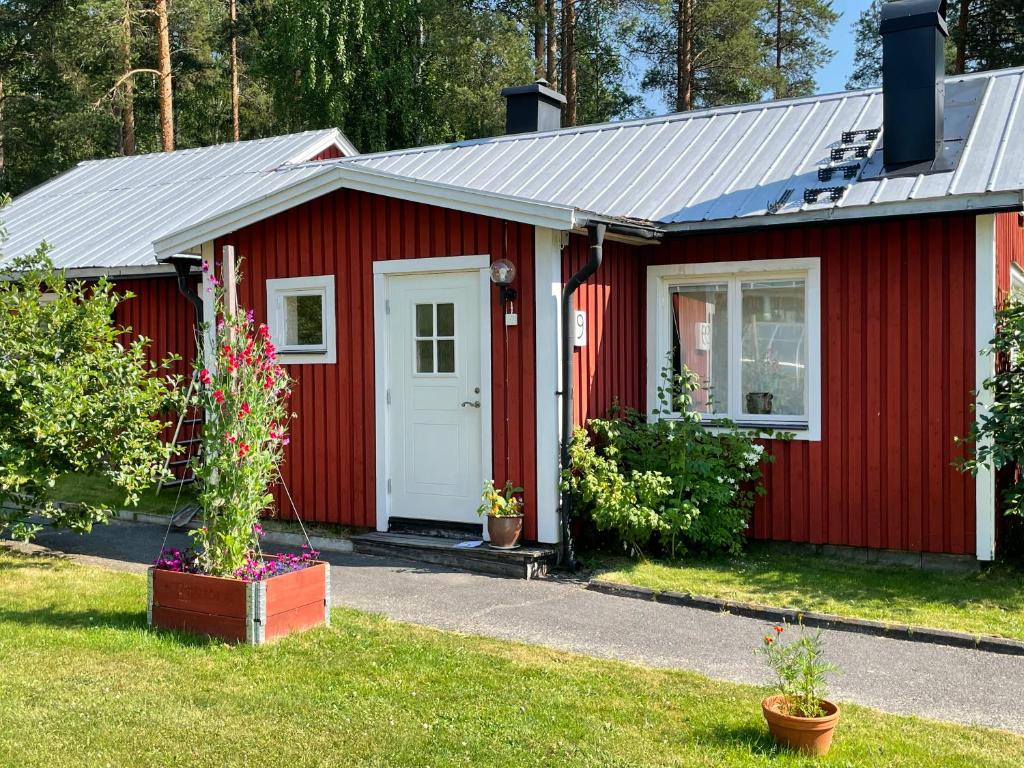 einen roten Schuppen mit weißer Tür in der Unterkunft Litet hus utanför Luleå in Luleå