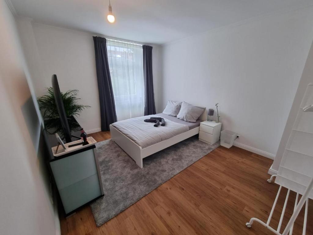 a white bedroom with a bed and a window at Süße Marie 4 in Karlsruhe