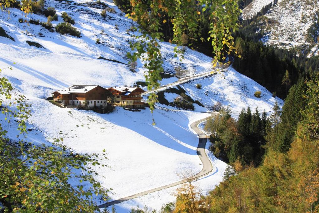 a house on a snow covered mountain with a road at Pfandlinghof in Grossarl