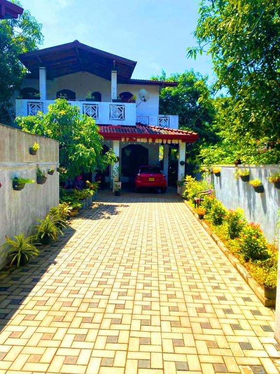 a driveway in front of a house with a car at Sylt Haus in Beruwala