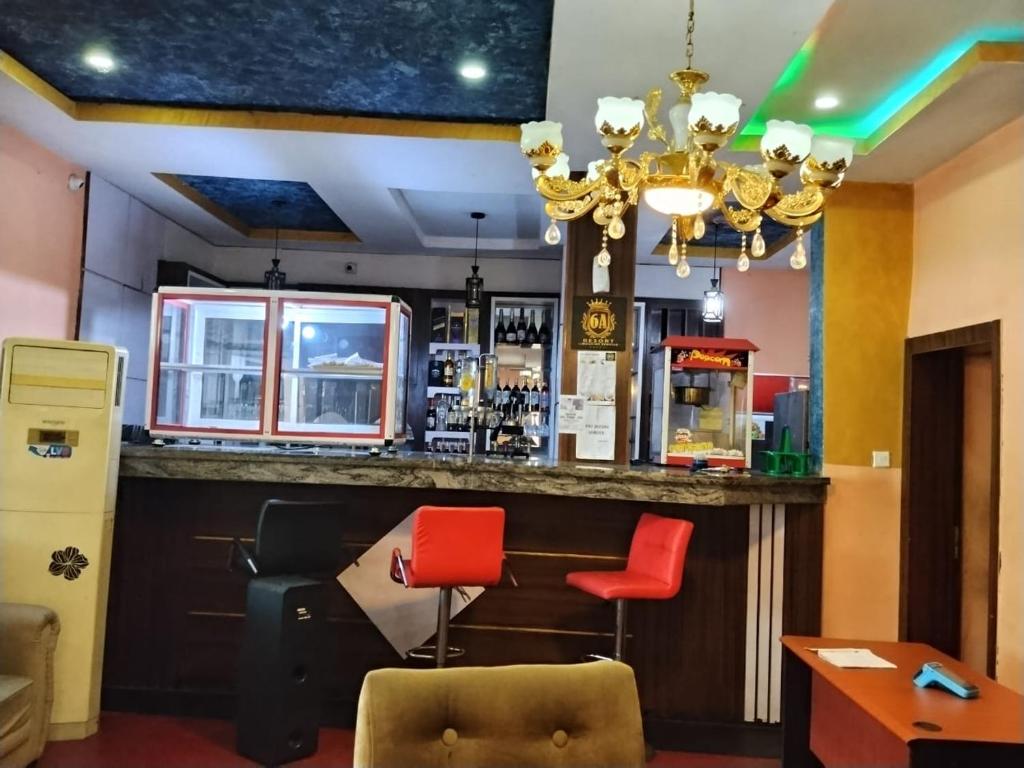 a bar in a restaurant with red chairs at 6A Resort in Owerri