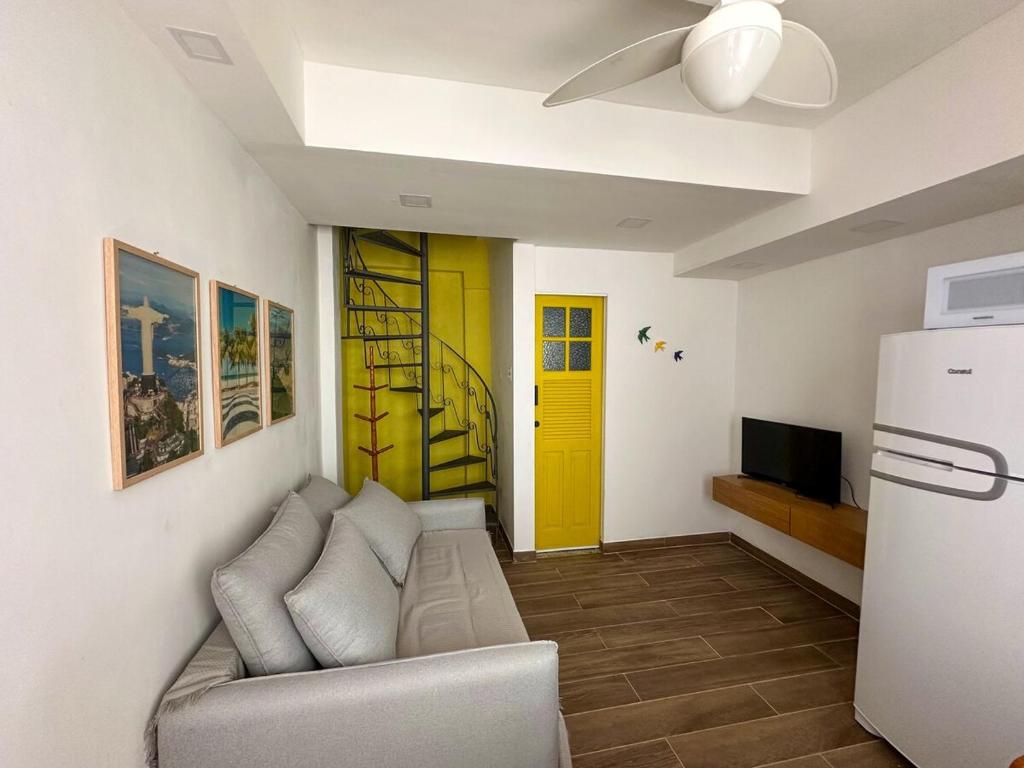 a living room with a couch and a yellow door at Vila em Laranjeiras in Rio de Janeiro