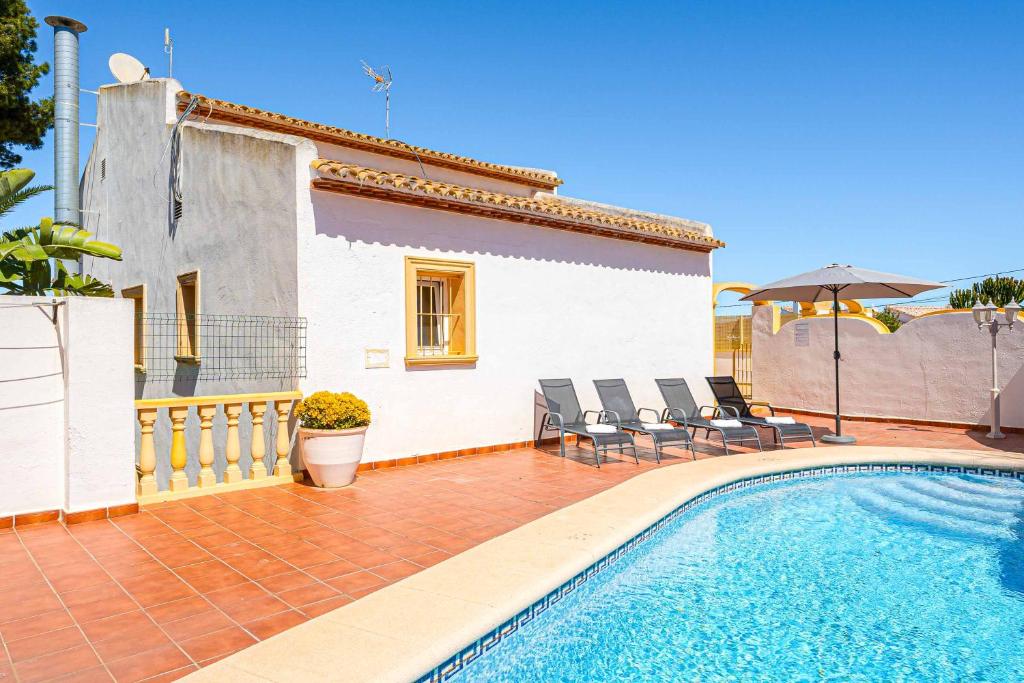 una villa con piscina di fronte a una casa di Villa Nispero a El Tosalet