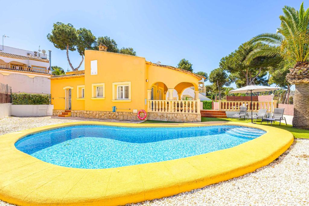 una casa con piscina di fronte a una casa di Villa Pera a El Tosalet