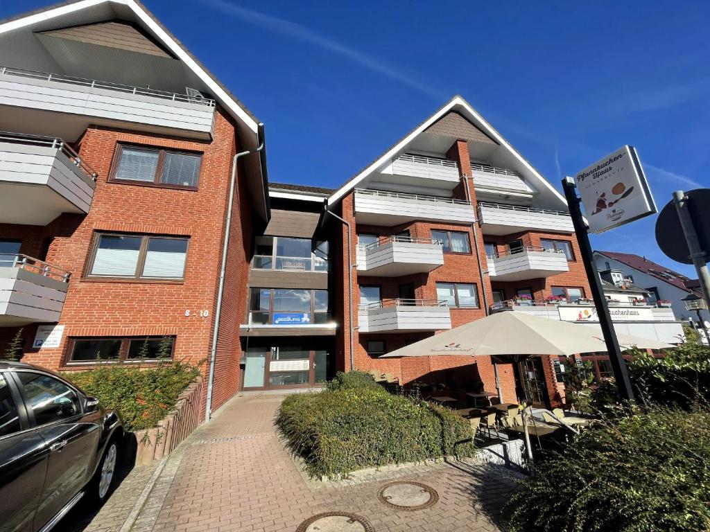 un edificio con un ombrellone e un'auto parcheggiata accanto di Haus Seeburg Appartement 2.6 - strandnah a Scharbeutz