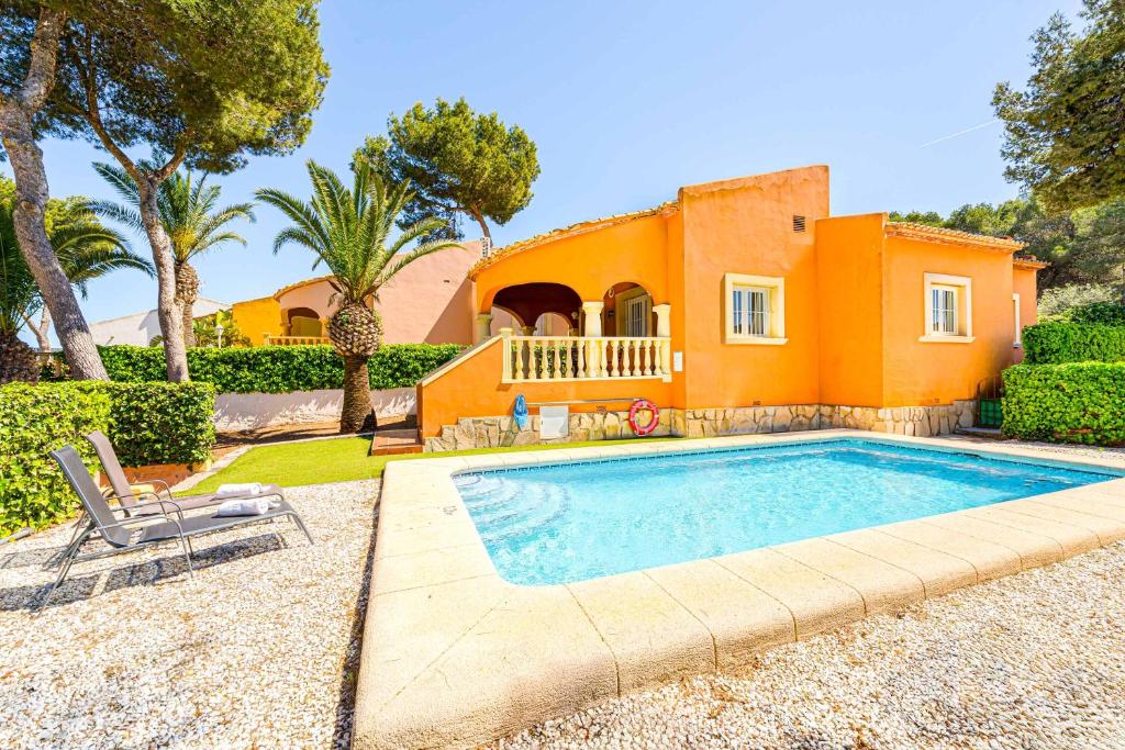 una casa con piscina di fronte a una casa di Villa Pinya a El Tosalet