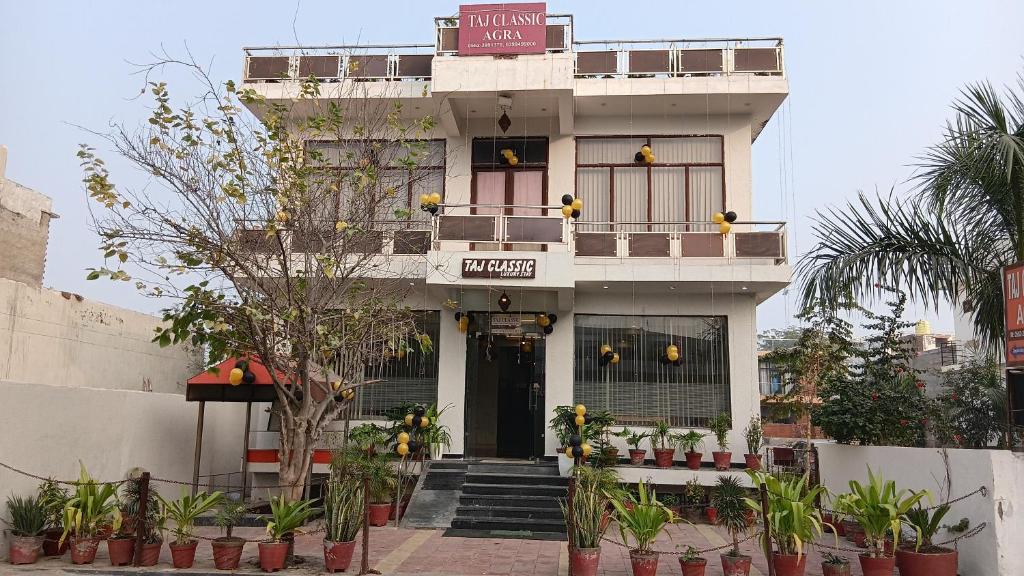 een wit gebouw met een balkon erboven bij Taj Classic Agra in Agra
