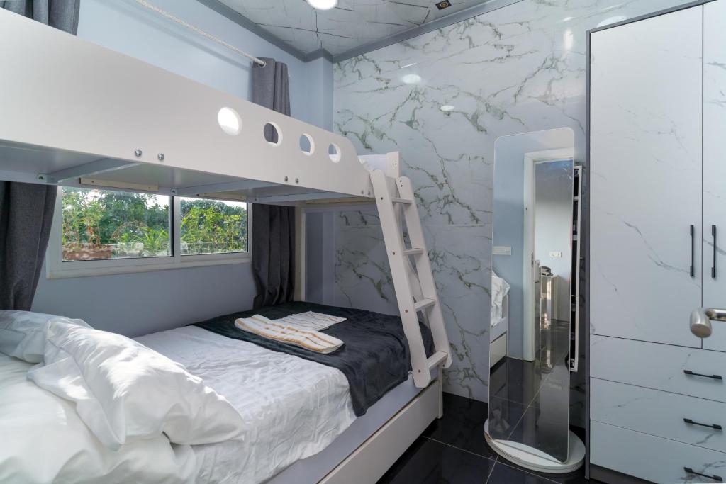 ein Schlafzimmer mit einem Etagenbett und einem Spiegel in der Unterkunft Naseema Hiya - Central Ukulhas Residences in Ukulhas