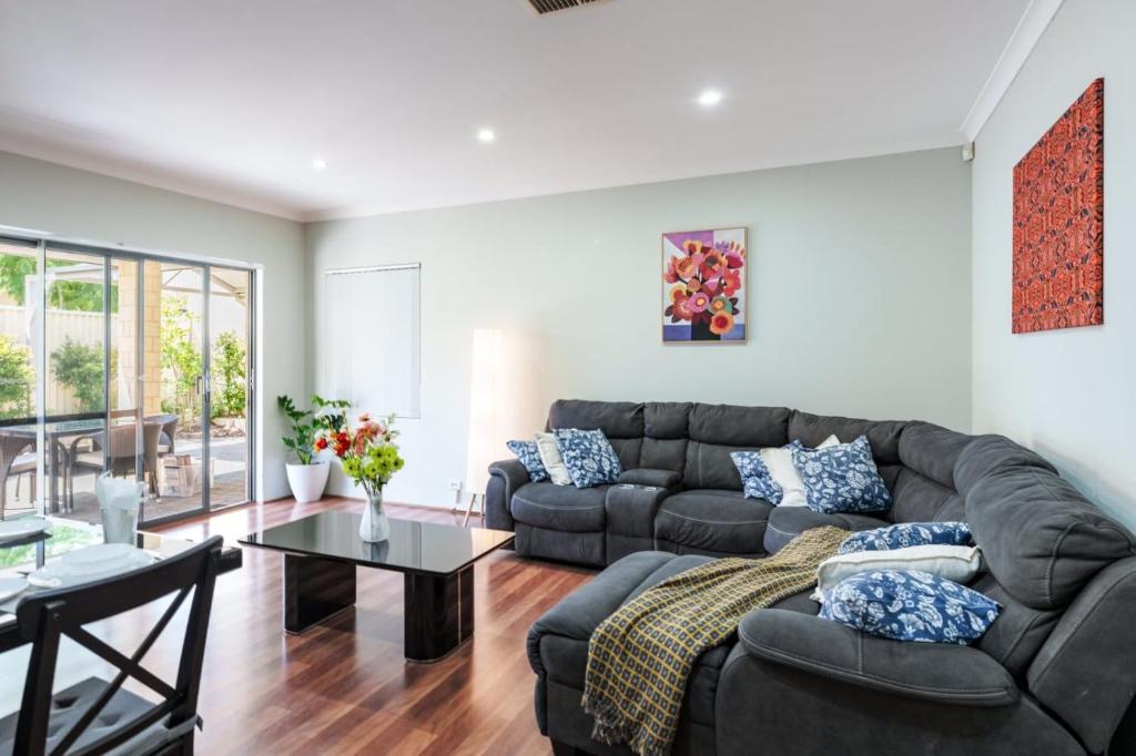 a living room with a couch and a table at Queens Residence Perth Western Australia in Perth