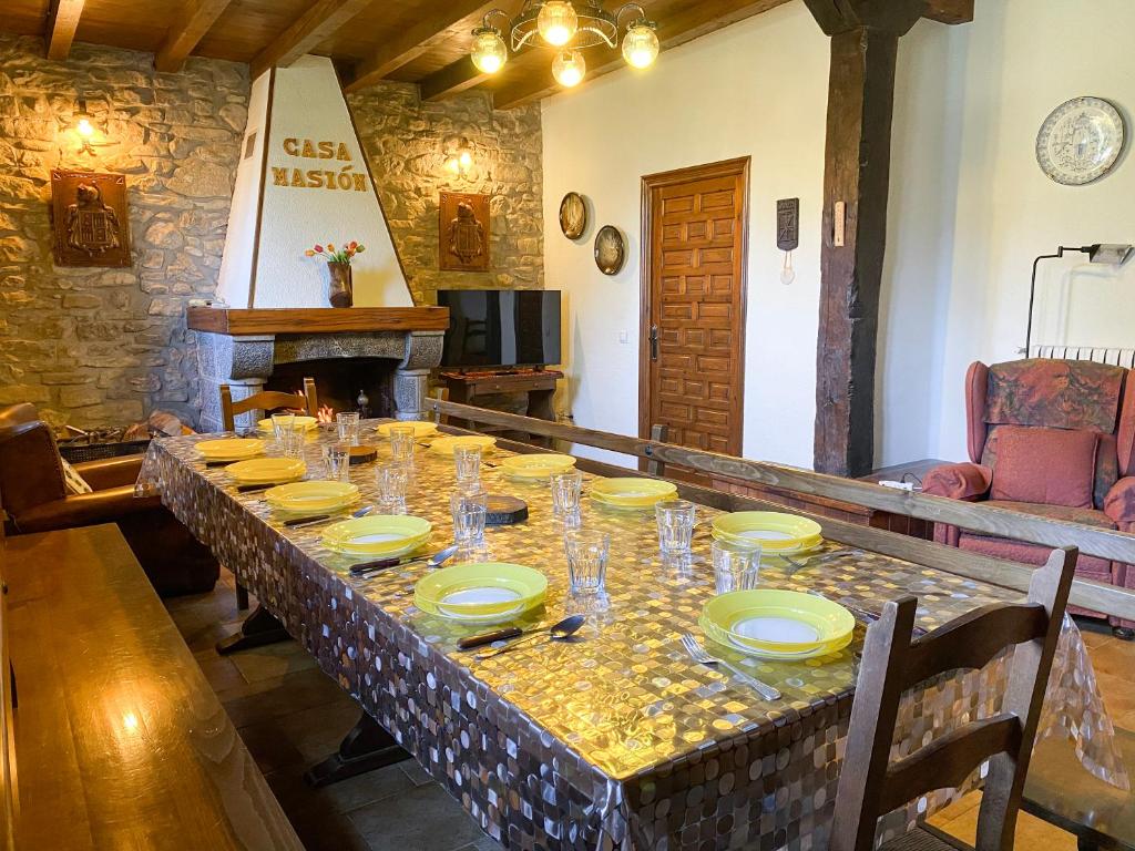 einen langen Tisch mit Tellern und Gläsern darauf in der Unterkunft Casa Rural Masión de Egüés in Elcano