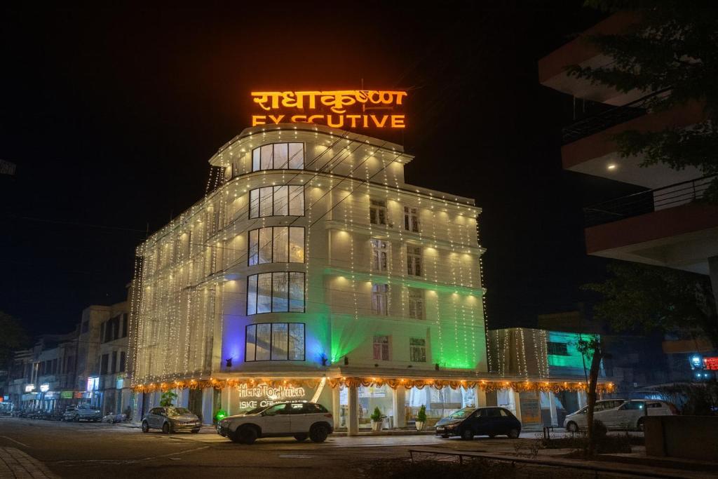 een gebouw met een bord erop 's nachts bij RadhaKrishna Executive in Tuljapur
