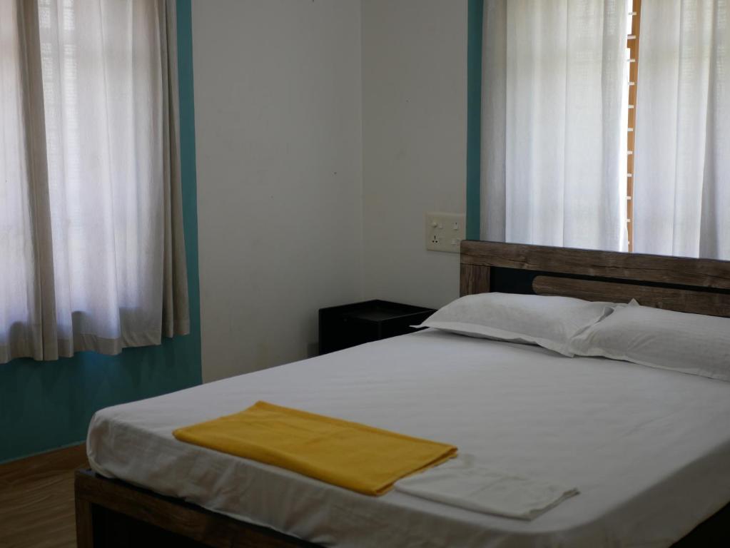 een slaapkamer met een bed met een gele handdoek erop bij PEARL SPOT Munroe Serviced Villa in Munroe Island