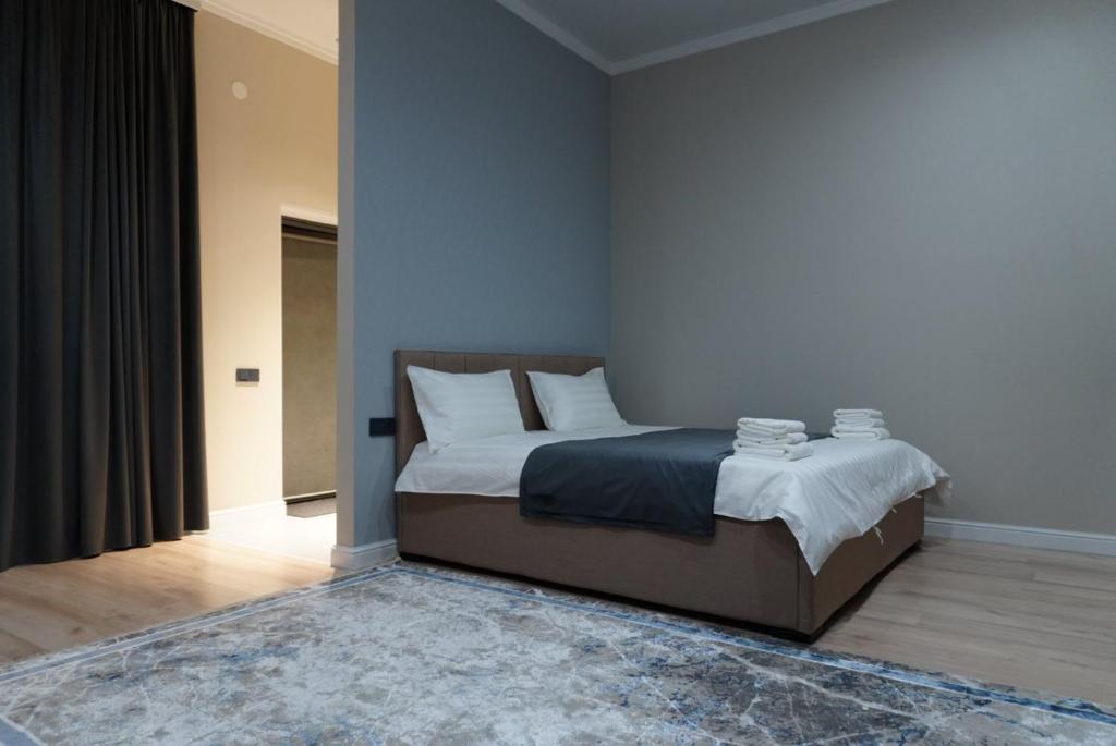 a bedroom with a bed with white sheets and pillows at AURA camping in Zhezdi