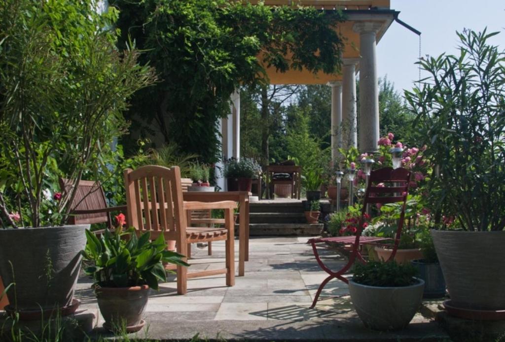 a patio with chairs and tables and potted plants at Villa Weißig in Struppen