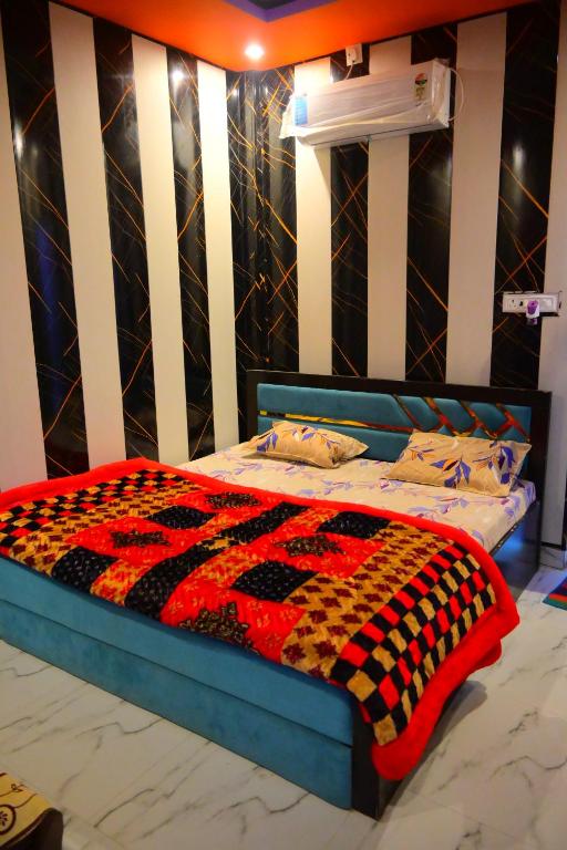 a bed with a checkered blanket on top of it at Mahakal homestay in Ayodhya