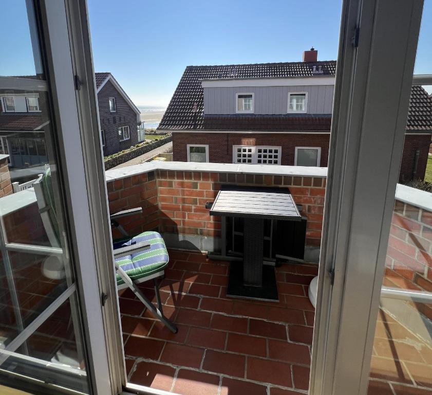 a view of a balcony with a table and a bench at Inselpause in Wittdün