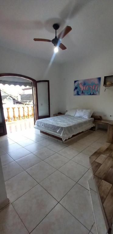 a bedroom with a bed and a ceiling fan at Suíte da Virada in Guarujá