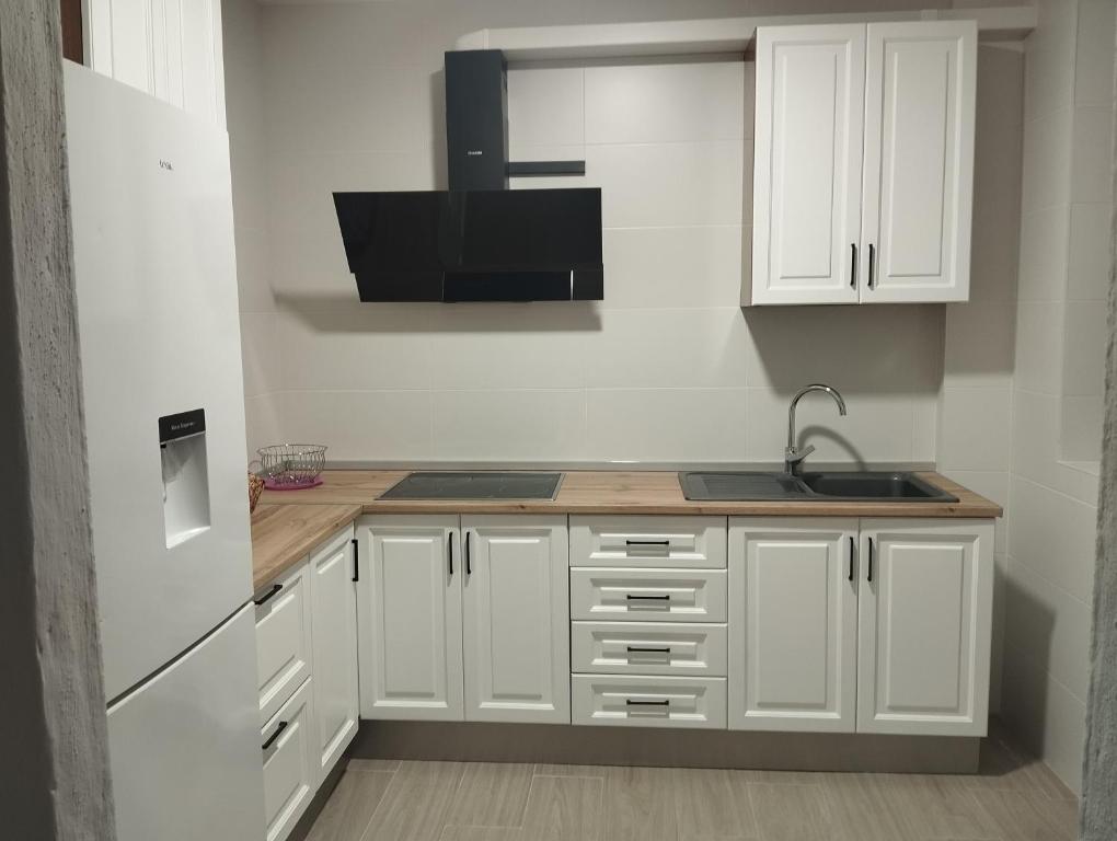 eine Küche mit weißen Schränken und einer Spüle in der Unterkunft El Lucentino in Lucena