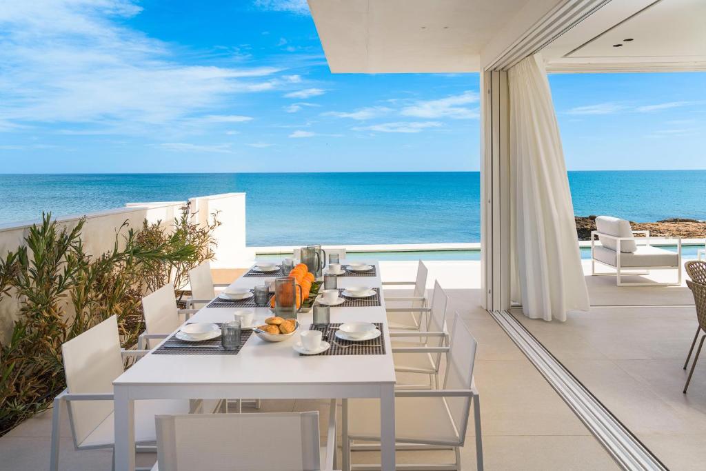 una sala da pranzo bianca con vista sull'oceano di Bedda Matri a Noto
