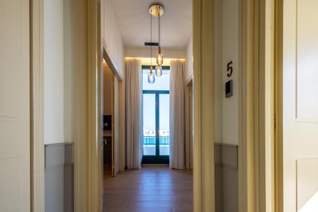 a hallway with a view of a room with a window at Promenade Chios Port Residences in Chios