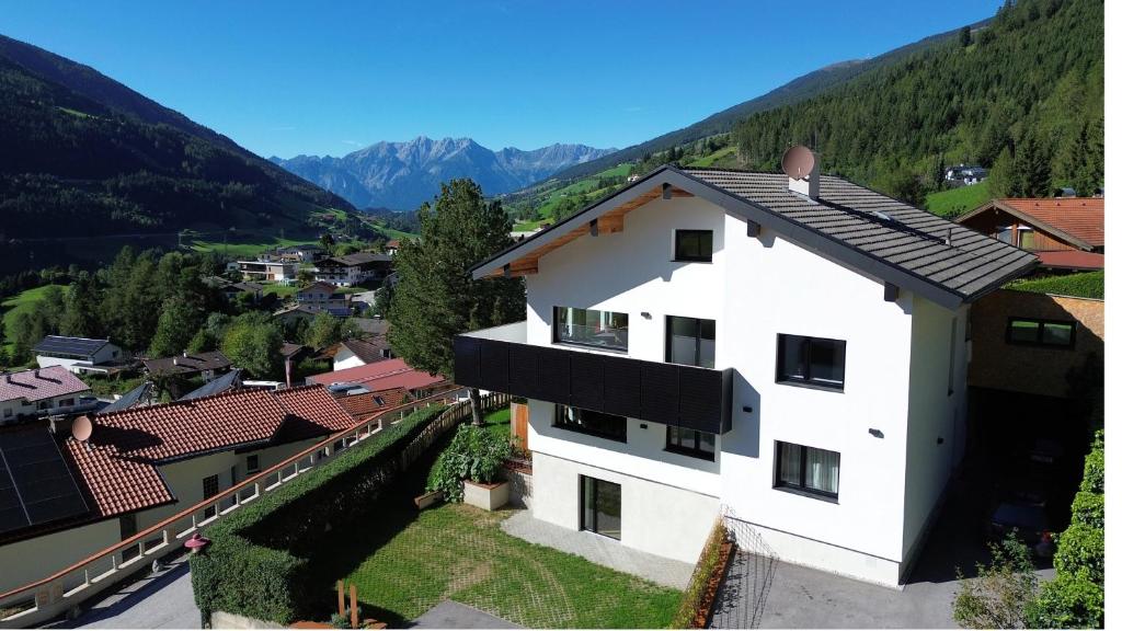 a white building with mountains in the background at Apartment Waldfrieden in Pfons