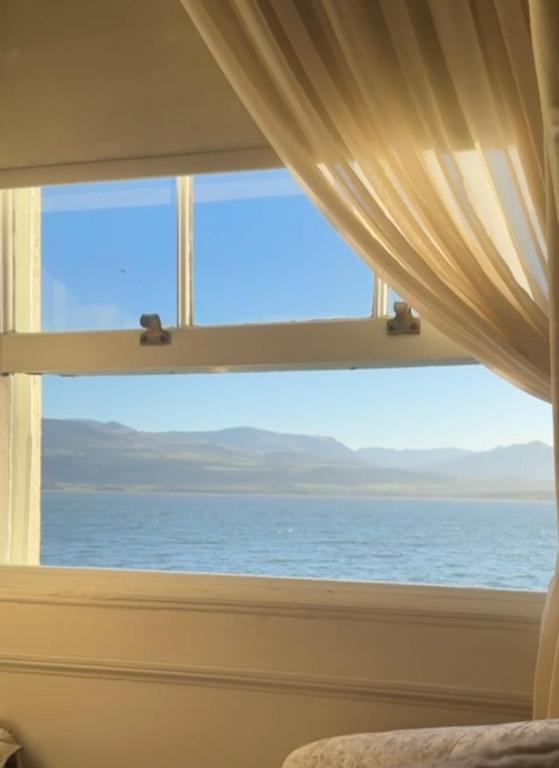 a bedroom window with a view of the ocean at The Suites At Ty Anne in Beaumaris