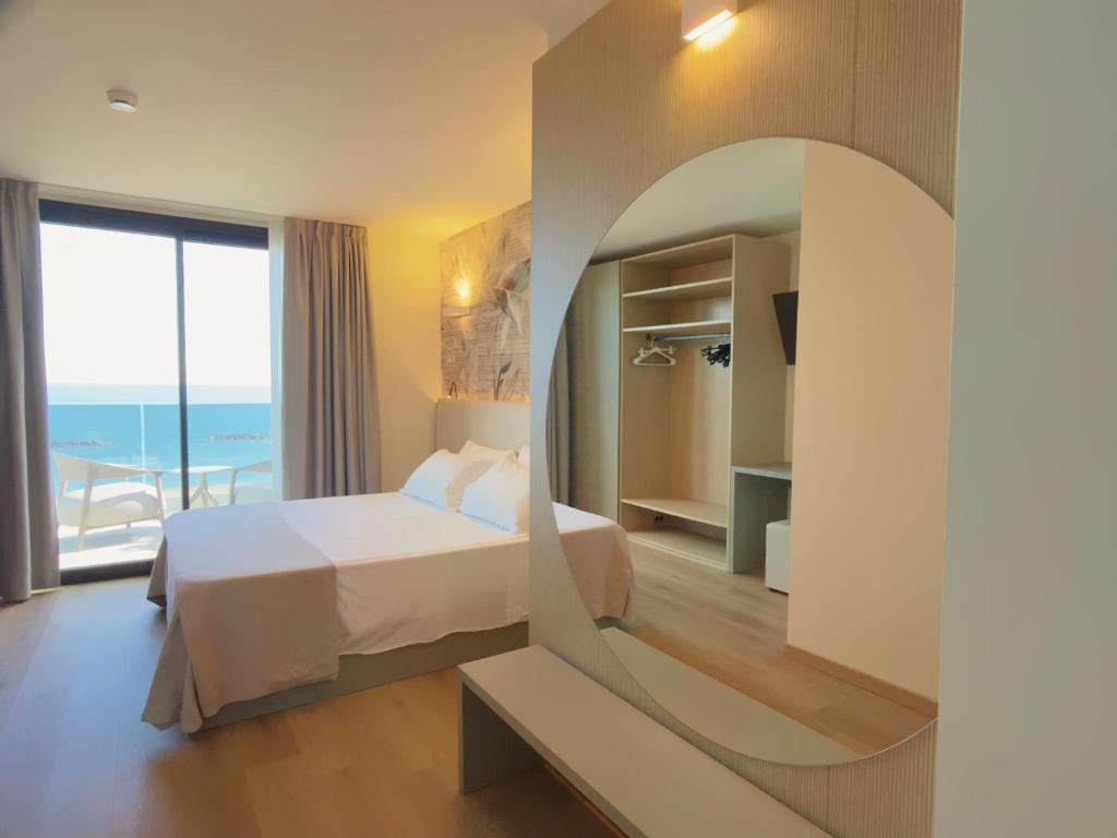 ein Schlafzimmer mit einem Bett und einem großen Fenster in der Unterkunft Hotel Continental in San Benedetto del Tronto