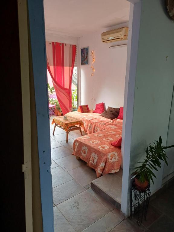 een kamer met twee bedden en een tafel erin bij Chez Brahim in Pointe-à-Pitre